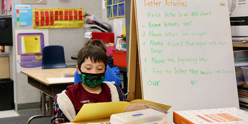 student reading wearing mask