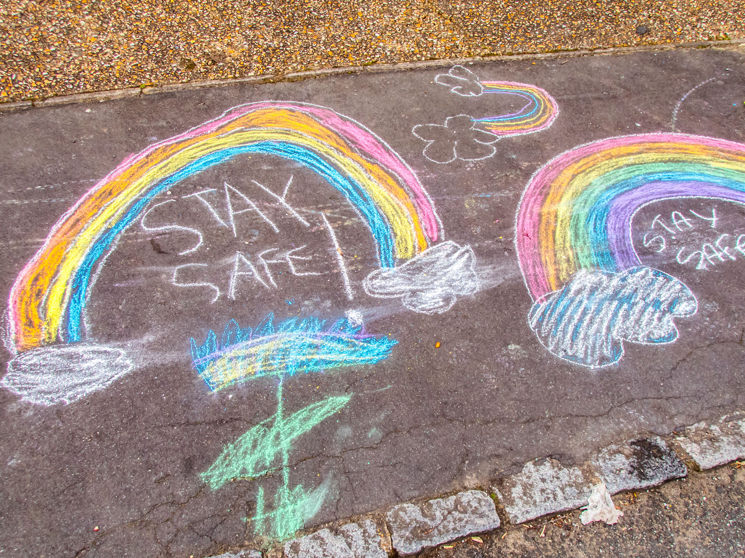 stay safe and chalk rainbows drawn on sidewalk